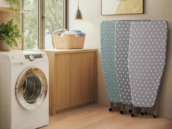 Laundry room with washing machine, ironing boards, and basket near a window.